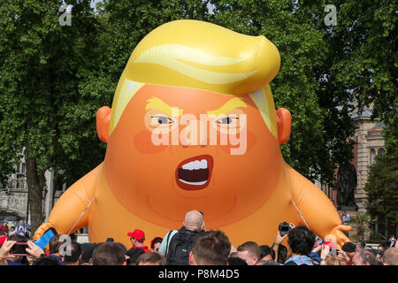 La piazza del Parlamento. Londra. Regno Unito 13 luglio 2018 - A sei metri di palloncino che illustra come il presidente statunitense Donald Trump un pannolino-placcati orange baby oltre la piazza del Parlamento durante il presidente del Regno Unito visita. Credito: Dinendra Haria/Alamy Live News Foto Stock