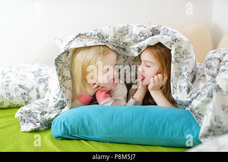 Due piccole sorelle giocando a letto sulla mattina di sole Foto Stock