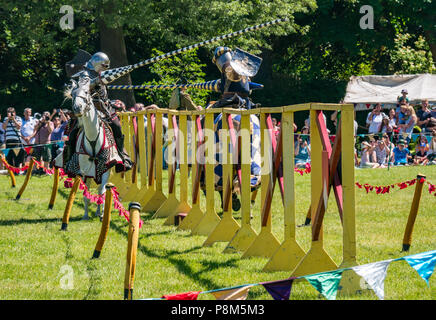 Giostra medievale, Linlithgow Palace, Scotland, Regno Unito. HES intrattenimento estivo da Les amis d'Onno equina team stunt. Cavalieri su cavalli giostra con lance Foto Stock