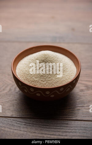 Materie farina di semola o Rava polvere è la grossa, purificato Farinetta di frumento di grano duro. Servito su sfondo semplice come un cumulo o in un contenitore o in un cucchiaio Foto Stock