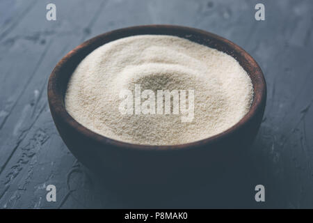 Materie farina di semola o Rava polvere è la grossa, purificato Farinetta di frumento di grano duro. Servito su sfondo semplice come un cumulo o in un contenitore o in un cucchiaio Foto Stock