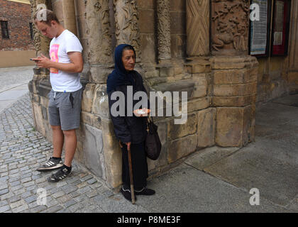 Donna anziana di accattonaggio all'ingresso Cattedrale di Wroclaw Slesia, Polonia, Europa Foto Stock