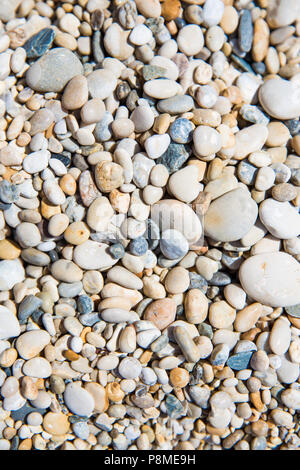 Un frame completo sullo sfondo di ciottoli e pietre su di una spiaggia di ciottoli in una trama di sfondo Foto Stock