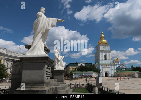 Vista delle statue di San Cirillo e Metodio in Piazza San Michele, con l'ingresso al monastero a cupola dorata di San Michele nella città di Kyiv o Kiev capitale dell'Ucraina Foto Stock