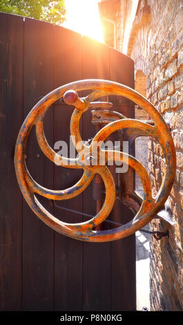 Abbandonata, rusty macchinari reliquia di mattoni e operazioni di produzione nella parte anteriore della vecchia porta di legno Foto Stock