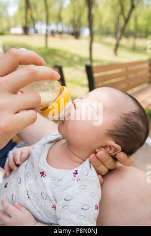 Un ritratto di carino neonato essendo alimentato con biberon Foto Stock