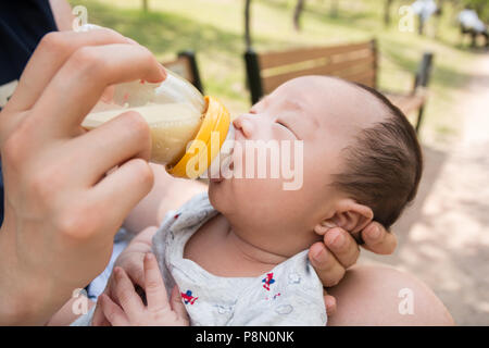 Un ritratto di carino neonato essendo alimentato con biberon Foto Stock