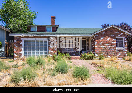 Abbandonato un livello Home ricoperta con cortile anteriore Foto Stock