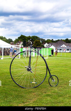 Penny Farthing bicicletta con un mazzuolo polo addossarsi al mondo Ciclismo Revival Festival 2018, London, Regno Unito Foto Stock