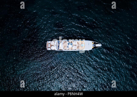 Vista aerea di uno yacht di lusso su un turchese e mare trasparente. Costa Smeralda, mare Mediterraneo, Sardegna, Italia. Foto Stock