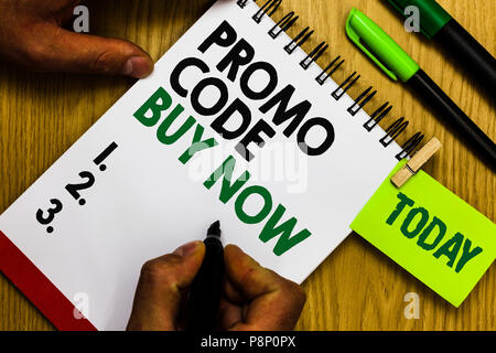 Testo della scrittura del codice promo acquista adesso. Concetto significato dare grande sconto immettendo parole speciali diario penna anello di blocco note marcatore script del puntatore Foto Stock
