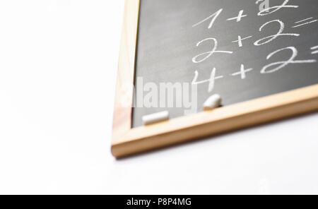 Frammento sfocata di lavagna nera con la scritta a mano semplici equazioni matematiche gessi bianchi. Si torna a scuola il concetto di apprendimento dell'istruzione. Creative Foto Stock