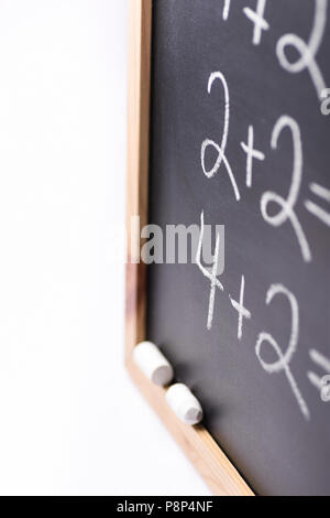 Frammento sfocata di lavagna nera con la scritta a mano semplici equazioni matematiche gessi bianchi. Si torna a scuola il concetto di apprendimento dell'istruzione. Creative Foto Stock