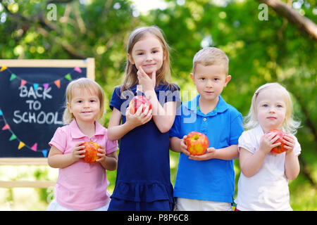 Quattro adorabili bambini piccoli sensazione molto entusiasti di tornare a scuola Foto Stock