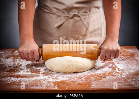 Casalinga appiattire un impasto con un mattarello Foto Stock