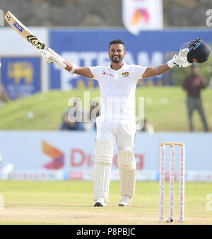 Il governo dello Sri Lanka cricketer Dimuth Karunaratne solleva il suo bat e casco in festa dopo aver segnato un secolo (100 corre) durante il primo giorno di apertura Test match tra lo Sri Lanka e il Sud Africa a Galle International Cricket Stadium di Galle su luglio 12, 2018 (foto di Lahiru Harshana / Pacific Stampa) Foto Stock