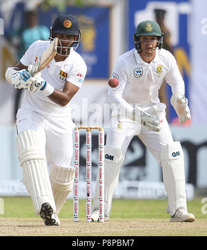 Il governo dello Sri Lanka cricketer Dimuth Karunaratne (L) gioca un colpo come Sud Africa Quinton de Kock guarda su durante il primo giorno di apertura Test match tra lo Sri Lanka e il Sud Africa a Galle International Cricket Stadium di Galle su luglio 12, 2018 (foto di Lahiru Harshana / Pacific Stampa) Foto Stock