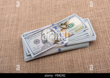 Chiave retrò e fascio di US dollar su una tela di canapa Foto Stock