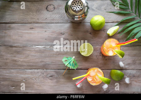 Cocktail di zombie con il rum, guarnita con calce. Dolce freddo frutti estivi alcool rosso cocktail, drink rinfrescante sul tavolo di legno, vista dall'alto. Foto Stock