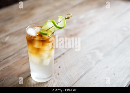 Buia e tempestosa Cocktail di Rum con birra allo zenzero e lime guarnire. Di vetro scuro e tempestoso cocktail drink sul tavolo di legno, copia dello spazio. Foto Stock