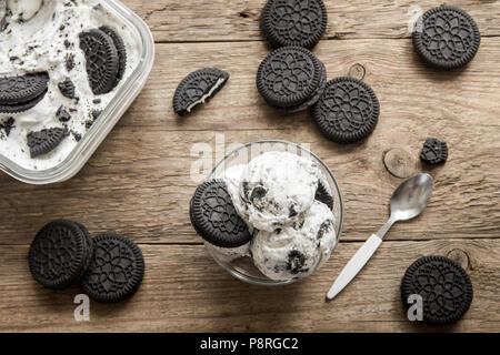 Gelato alla crema con cioccolato e crema biscotti sandwich. Cookie e la crema gelato fatto in casa dolce il legno scuro dello sfondo. Foto Stock
