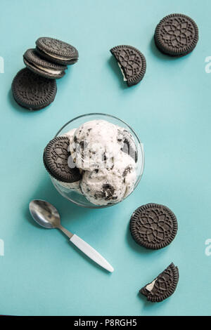 Gelato alla crema con cioccolato e crema biscotti sandwich. Cookie e la crema gelato artigianale dessert su sfondo blu, copia dello spazio. Foto Stock
