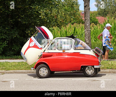 A Garching, Germania-luglio 8, 2018. Auto d'epoca BMW Isetta 300 bicolore rosso e bianco crema con porta aperta e aprire il tetto del sole presso la tradizionale sfilata f Foto Stock