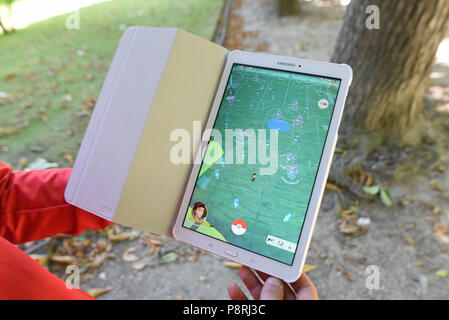 Luglio 14, 2016 - Parigi, Francia: un giocatore mostra la mappa sul suo tablet come egli prende parte in una massa Pokemon hunt nel giardino del Lussemburgo nel centro di Parigi. Centinaia di giocatori del nuovo Pokemon Go gioco ha mostrato fino a prendere parte a una massiccia caccia nonostante le autorità devono tentare di annullare l'evento. Nonostante la riproduzione per la maggior parte solo, il Pokemon andare gli utenti goduto di interagire e di incontrare altri giocatori. Milioni di utenti hanno già scaricato il gioco che richiede agli utenti di catturare sullo schermo pokemon i caratteri usando la loro reale posizione. Des jeunes participent un une chasse au Pokemons dans le Jardin du Lu Foto Stock
