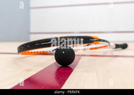 Racchette da squash e la sfera sdraiato sul pavimento di legno di una corte Foto Stock