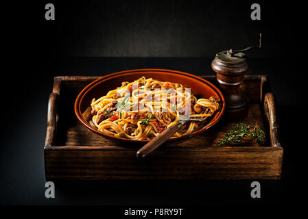 Delizioso spaghetti con ragù alla bolognese servita su sfondo nero Foto Stock