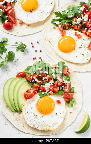 Flatbread con avocado, uova e salsa messicana, verticale, primo piano Foto Stock