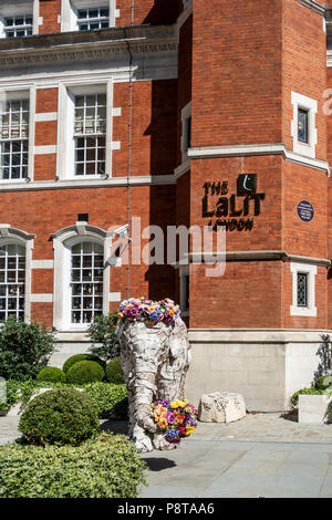 Statua di elefante con fiori al di fuori del Five Star Indian-owned Lalit Hotel nel centro di Londra, costruito nell'ex St Olave school. Inghilterra, Regno Unito Foto Stock