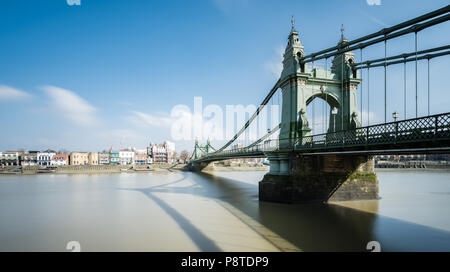 Una lunga esposizione vista del paesaggio di Hammersmith Bridge, Londra, guardando in direzione di Chiswick e riverside pub Foto Stock