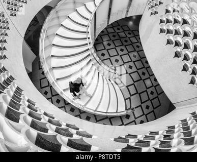 Vista dal di sopra della donna che cammina verso il basso una scalinata a spirale alla Tate Modern di Londra Foto Stock