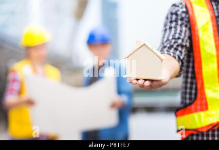 Casa o home modello con successo il lavoro di squadra di ingegnere civile concetto con copia spazio di incontro di sfocatura dell'ingegnere con blueprint su architettura Foto Stock