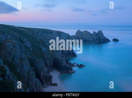 Lo spuntar del giorno su Logan Rock Porthcurno vicino a West Cornwall Foto Stock