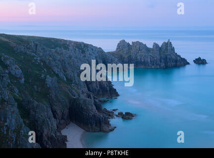 Alba di rottura di luce su Logan Rock vicino Porthcurno in Cornovaglia Foto Stock