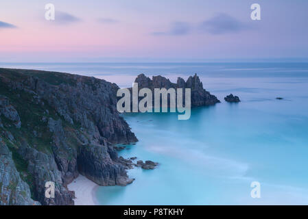 Tramonto su Logan Rock Porthcurno vicino a West Cornwall Foto Stock