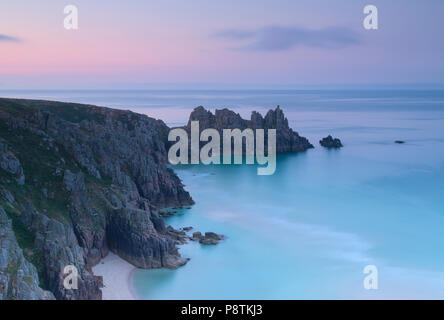 Tramonto su Logan Rock Porthcurno vicino a West Cornwall Foto Stock