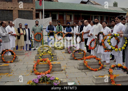 Budgam, Jammu e Kashmir in India. 13 Luglio, 2018. Il governo indiano funzionari prevede una corona sul graves al martire il cimitero a Srinagar, la capitale estiva della controllata indiana Kashmir India, durante una cerimonia di premiazione che si terrà a segnare il martirio anniversario della Kashmiris ucciso dall'esercito di un re indù. Le autorità indiane a Srinagar distribuito migliaia di personale di sicurezza nelle principali città di Srinagar per impedire l'anti-Indiani proteste nell'area del centro cittadino di Srinagar. Ogni anno il 13 luglio Kashmir osserva il martirio anniversario di 23 musulmani che sono stati uccisi dalle forze del Maharaja Hari Foto Stock