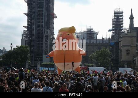 Londra, 13 Luglio 2018: un alta 6 metri elio gonfiabile riempito di Presidente Trump raffigurato come un gigante arrabbiato orange baby indossando un nappie è sollevata sopra la piazza del Parlamento da attivista protestando la sua visita nel Regno Unito. Credito: Claire Doherty/Alamy Live News Foto Stock