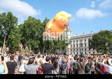 Londra, 13 Luglio 2018: un alta 6 metri elio gonfiabile riempito di Presidente Trump raffigurato come un gigante arrabbiato orange baby indossando un nappie è sollevata sopra la piazza del Parlamento da attivista protestando la sua visita nel Regno Unito. Credito: Claire Doherty/Alamy Live News Foto Stock