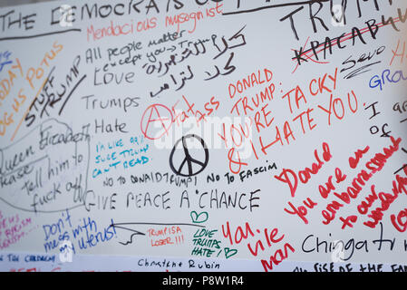 Persone che scrivono sulla parete Awaaz con commenti per Donald Trump. Decine di migliaia di persone hanno marciato e protestato contro la Trump visita al Regno Unito. Il mese di marzo è iniziato in Regent Street e si è conclusa a Trafalgar Square. Foto Stock