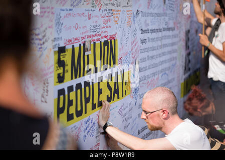 Persone che scrivono sulla parete Awaaz con commenti per Donald Trump. Decine di migliaia di persone hanno marciato e protestato contro la Trump visita al Regno Unito. Il mese di marzo è iniziato in Regent Street e si è conclusa a Trafalgar Square. Foto Stock