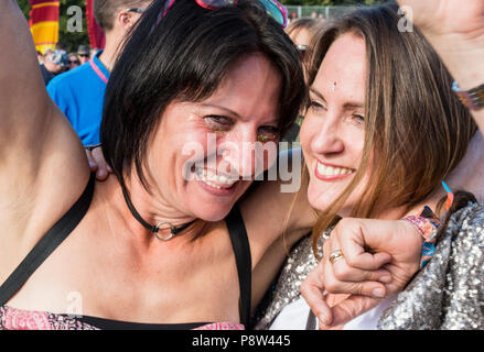 Due festival goer amici gustando la musica all'Obelisco stadio a Latitude Festival, Henham Park, Suffolk, Inghilterra, 13 luglio 2018. Foto Stock