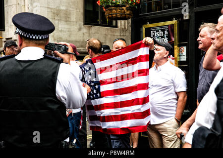 Londra, UK, 2debitamente 2018. Un britannico Pro-Trump sostenitore è visto con in mano una bandiera statunitense. Protesta da parte di anti-Trump sostenitori contro Donald Trump's visita al Regno Unito che ha avuto luogo nel centro di Londra. Credito: SOPA Immagini limitata/Alamy Live News Foto Stock