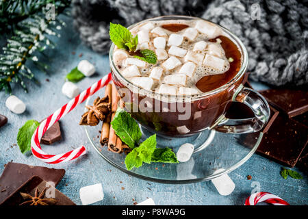 In casa la cioccolata calda con la menta, candy cane e marshmallow, luce sfondo blu con la calda coperta, spazio di copia Foto Stock