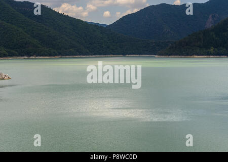 La luce che colpisce oltre un fiume di acque verde con alcune montagne & nuvole in cima a amer, Spagna Foto Stock