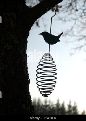 Metallo ornamento di uccelli appesi da un albero Foto Stock