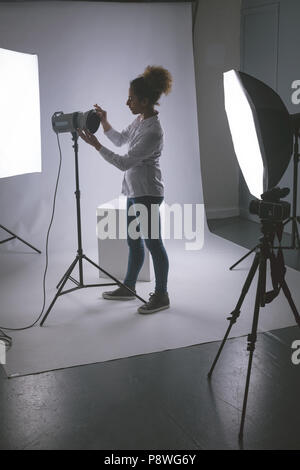 Fotografo femmina regolazione fari stroboscopici Foto Stock